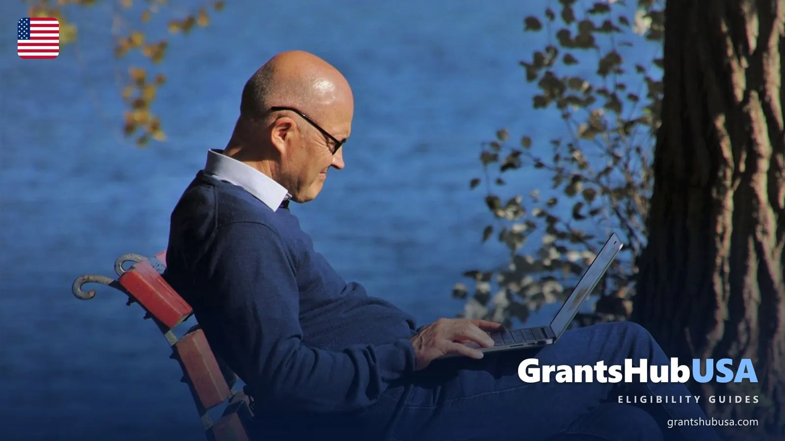 Retired man in glasses using a laptop on a park bench by a lake in autumn, a reminder to check your 2027 COLA notice online